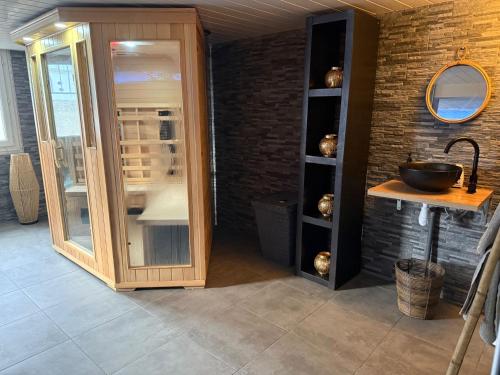 une pièce avec un lavabo et un comptoir avec une armoire vitrée dans l'établissement Suite SPA PRIVÉE, à Portet-sur-Garonne