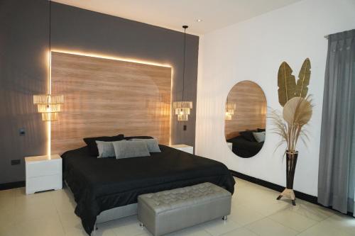 Un dormitorio con una cama, una silla y un espejo. en Dharma Hotel Boutique Spa, en San Jerónimo