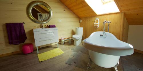 y baño con lavabo, espejo y aseo. en Chambres d'hôtes Couleurs Bois & Spa, en Xonrupt-Longemer