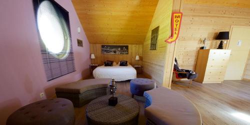 une chambre d'hôtel avec un lit, un canapé et des chaises dans l'établissement Chambres d'hôtes Couleurs Bois & Spa, à Xonrupt-Longemer