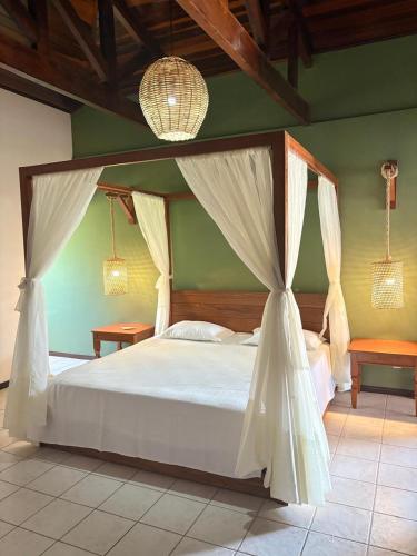 a bedroom with a white bed with a canopy at Lagoa Eco Village in Pipa