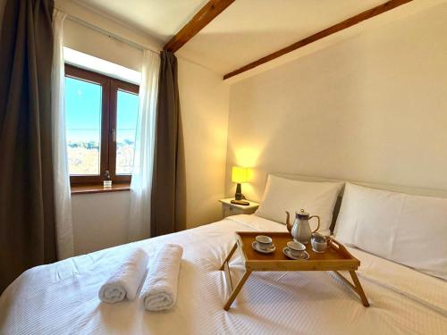 a bedroom with a bed with a table on it at Villa Billubium - Dalmatian Stone House with Private Heated Pool in Zovko