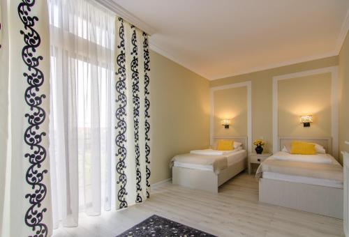 a bedroom with two beds and a window at Seva Hotel Health Club in Campina