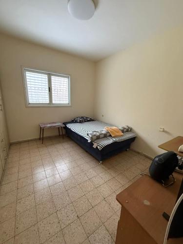 a bedroom with a bed in the corner of a room at דירת ציון in Petaẖ Tiqwa