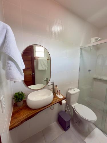 a bathroom with a sink and a mirror and a toilet at Yahweh Hotel in São Miguel do Gostoso