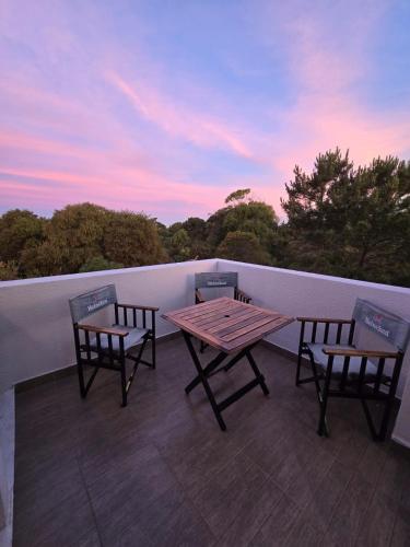 2 stoelen en een houten tafel op een balkon bij Complejo la argentina in Ostende