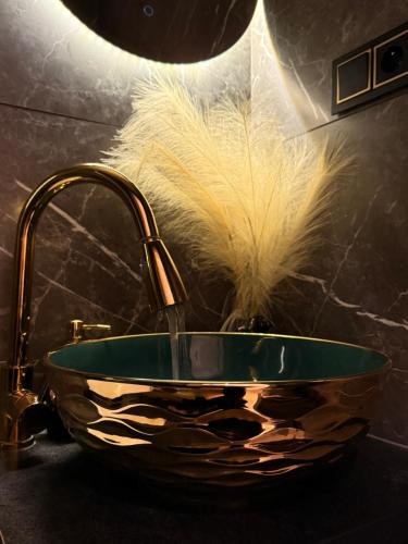 a bathroom sink with a faucet with a feather in it at Leśny Azyl in Zwierzyniec