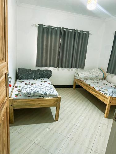 a living room with two beds and a window at njiro one in Arusha