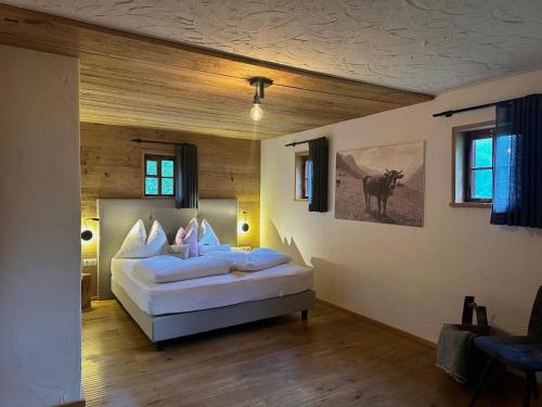 Bergchalet h e i m a t في سان مارتينو: غرفة نوم فيها سرير ومخدات بيضاء