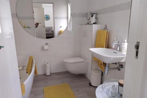 ein Badezimmer mit Waschbecken, Toilette und Spiegel in der Unterkunft Luxury Beach Front Apartment in Strand