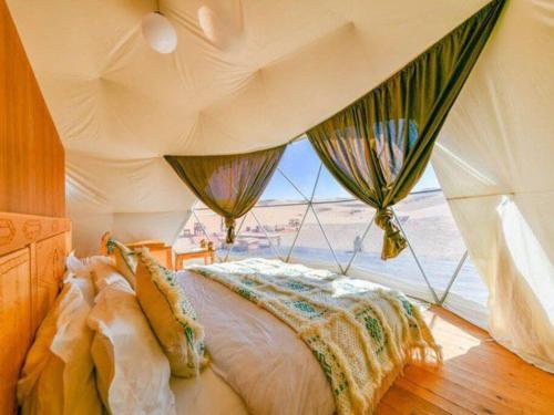 Un dormitorio con una cama y una ventana en Hayati Desert Luxury Camp, en Merzouga