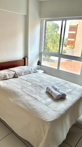 un letto con due asciugamani sopra di fronte a una finestra di Refúgio à Beira-Mar Cabo Branco João Pessoa a João Pessoa