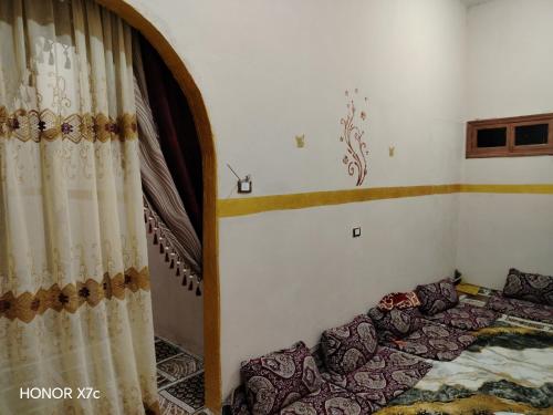 um quarto com uma cama e uma cortina em البيت السيوي em Oásis de Siuá