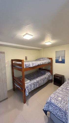 a bedroom with two bunk beds in a room at Hostal Del Tuto in Punta Arenas