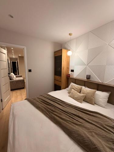 a bedroom with a large bed and a chair at Leśny Azyl in Zwierzyniec