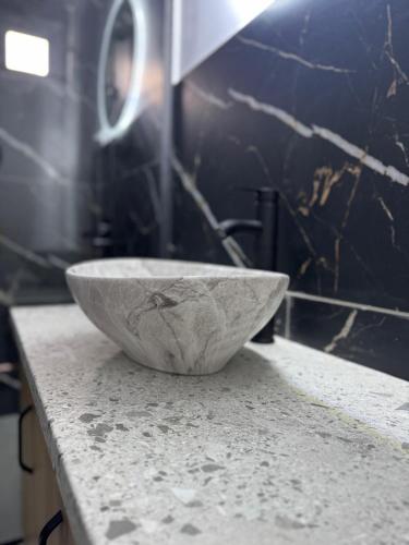 a stone bowl sitting on a counter in a bathroom at Joy Chalet in Plaiu
