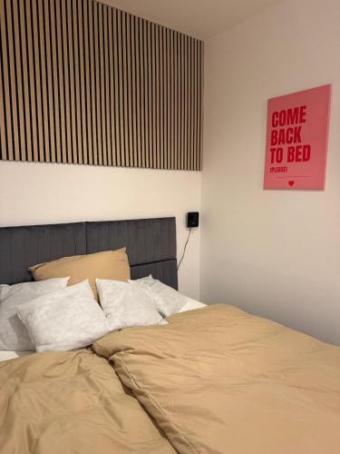 a bed in a bedroom with a sign on the wall at Stylish Studio in Linz Old Town Cozy & Central in Linz