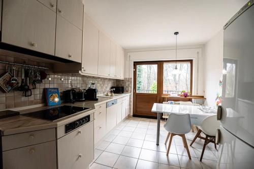 une cuisine avec des armoires blanches et une table avec des chaises dans l'établissement Forest View Quiet and Central, à Hesperange