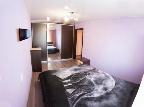チュメニにある2kv Apartment Center Gudvinのベッドルーム1室(壁に絵画が描かれたベッド1台付)