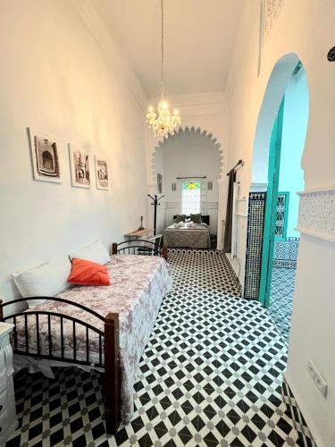 a bedroom with a bed and a chandelier at Riad Nostalgie of Tetouan in Tétouan