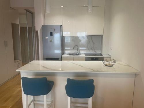 una cucina con bancone e 2 sgabelli blu di Apartman Savanovic a Banja Luka