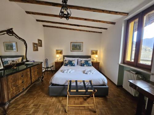 a bedroom with a bed and a desk and windows at Dimora Paradise in Laglio