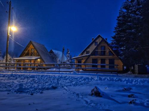 a log cabin in the snow at night at Evergreen cabins Golija in Golija
