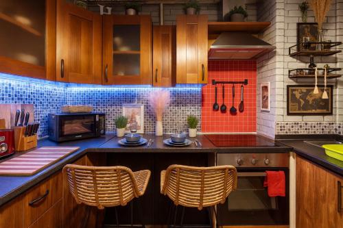 a kitchen with a stove and some chairs in it at The Serene Residence with Hot Tub, Sauna and Cinema Experience in London