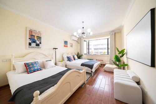 a bedroom with two beds and a couch at Tonight Homestay Jing'an Temple Branch Shanghai in Shanghai