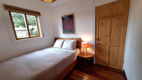 Casa Cabuya - Retro Style with Gulf View in Monteverde في مونتيفيردي كوستاريكا: غرفة نوم بها سرير ونافذة وباب