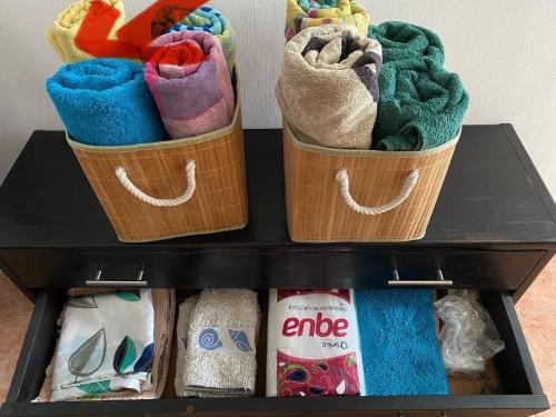 trois paniers remplis de serviettes sur une étagère dans l'établissement La Preneuse sur Mer Appartement, à Rivière Noire