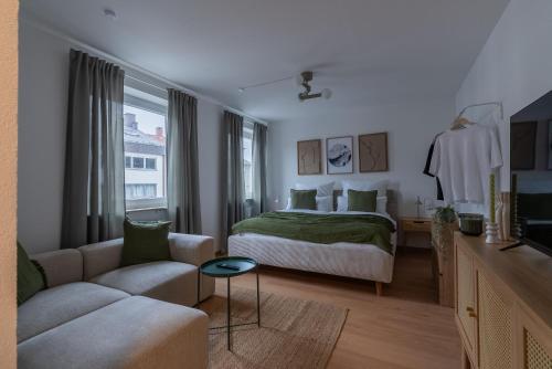 une chambre d'hôtel avec un lit et un canapé dans l'établissement SaLi - Design Apartments, à Trossingen