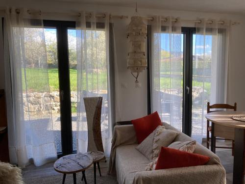 a living room with a couch and large windows at Maisonnette Hauts d'Evian in Larringes
