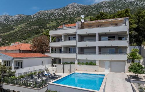 an apartment building with a swimming pool and a mountain at 1 Bedroom Stunning Apartment In Dingac in Gornji Dingač