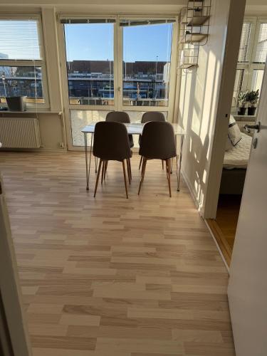 2 bedroom apartment in the heart of Randers في راندرس: غرفة طعام بها طاولة وكراسي ونوافذ