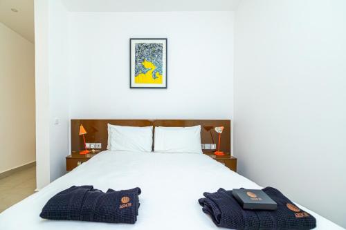 a bedroom with a bed with two bags on it at Arbor Boutique Stay in Brufut