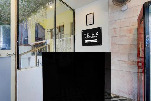 a black sign on a wall next to a door at Collection O Baga Beach Goa Formerly Traveller Guest House in Baga