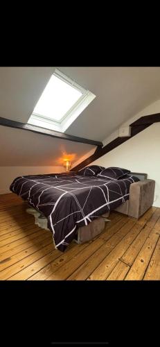 a bedroom with a bed with a skylight in a attic at Logement atypique in Asnières-sur-Seine