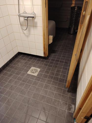 a bathroom with a tile floor and a sink at Lomariihi 6 in Muurame