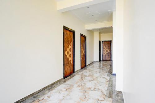 un corridoio con quattro porte e pavimenti in marmo di SPOT ON Hotel Bella Vista a Jhinjhak