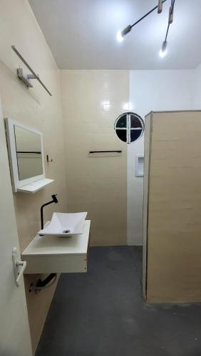 a bathroom with a white sink and a mirror at Pousada Gaturama suite 1 in Corumbá