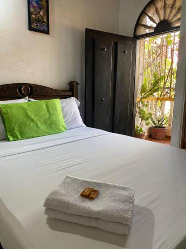 a white bed with a towel on top of it at Hotel Casa Vieja in Santa Marta
