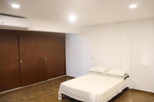 een slaapkamer met een bed en een kast bij Habitacion con baño privado La Perla in Acapulco