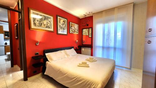 Relax & Comfort 30 min from Milan and Rho Fair في نوفارا: غرفة نوم حمراء عليها سرير وفوط