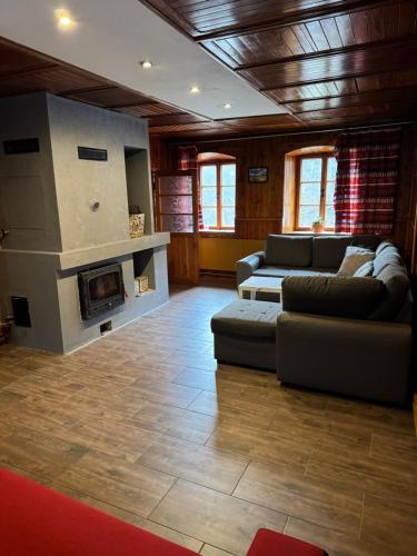 Una sala de estar con un sofá y una chimenea. en Sauna Chata BedRich, en Bedřichov