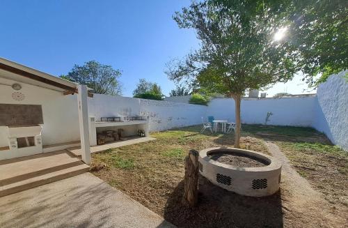 een boom in een pot naast een witte muur bij Achalay in Bialet Massé