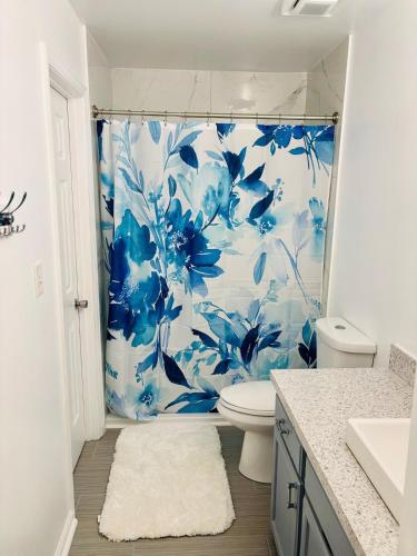 a bathroom with a blue and white shower curtain at The Williamsburg Haven in Williamsburg