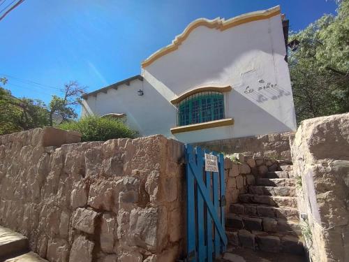 a house with a blue gate and a stone wall at Casona de los Molles in Tilcara