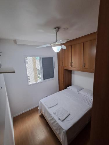 Un dormitorio con una cama y un ventilador de techo. en Family Flat PG - Praia, Musica e Gastronomia, en Praia Grande