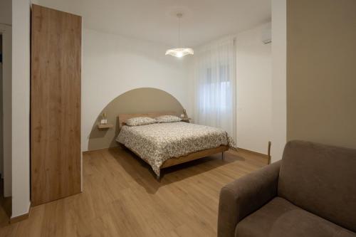 ein Schlafzimmer mit einem Bett und einer Couch in der Unterkunft Casa di Viola - Fiori d arancio in Latina